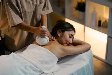 Terapist omzundaki gerilimi azaltmak için geleneksel bir bitki topu kullanıyor. Refah kavramı.