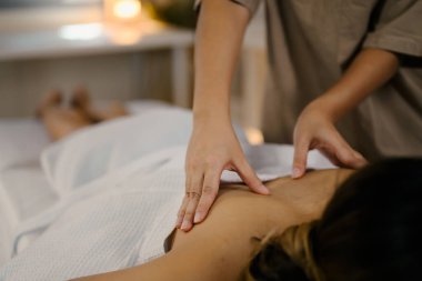 Tedavi masasında tedavi edici vücut masajından hoşlanan kadın hasta sakin bir ambiyans ile. Refah kavramı.