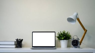 Bilgisayarı, kahve fincanı, not defteri ve kapalı salonda bitkileri olan parlak ofis masası...