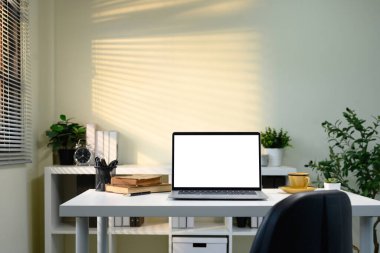 Dizüstü bilgisayarı, kalem tutacağı, saksısı ve günlüğü olan şık bir çalışma istasyonu..