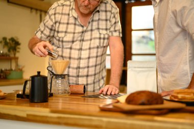 Son sınıf öğrencisiyle oğlu sıcak bir mutfakta kahvelerini yudumluyorlar. Babalar Günü konsepti.