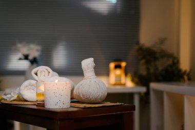 Yuvarlak beyaz havlular, çiçek ve mum serin bir kaplıcada bir masaya dizilmiş..