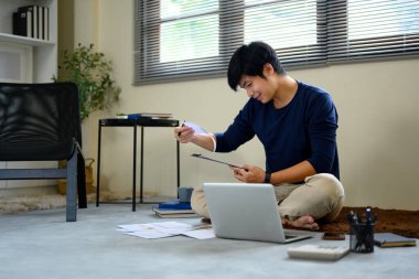 Masrafları ve faturaları ev ofisinden inceleyen ve faturaları inceleyen adam..