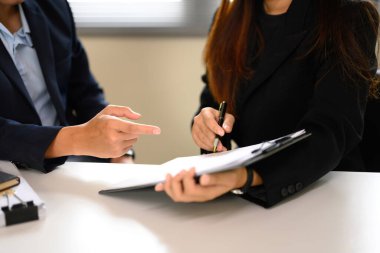 Ofis masasında kontrat detaylarını tartışan iş profesyonellerini kapatın..