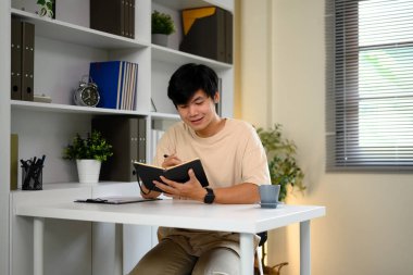 Asyalı bir adam evde sakin bir sabah geçirirken kişisel günlüğüne düşünceler yazıyor..