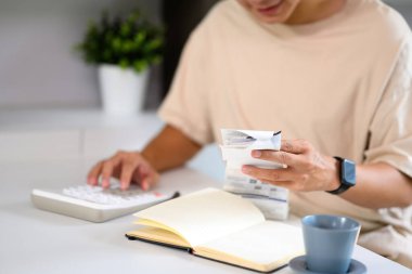 Ev giderlerini fatura ve hesap makinesiyle yöneten adamın yakın plan fotoğrafı..