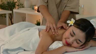 Masaj terapisti ona masaj yaparken rahatlamış kadın..