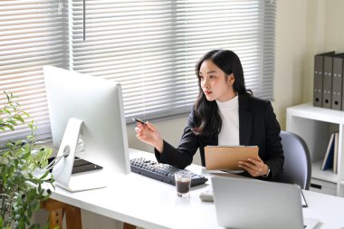 İş kadını iş performansını analiz ediyor ve bir iş sırasında içgörüye işaret ediyor.