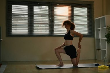 Evde yoga yapan formda bir kadınla sabah antrenmanı..