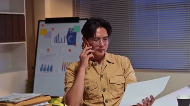 Gece yarısı ofiste telefonla konuşan meşgul bir girişimci..