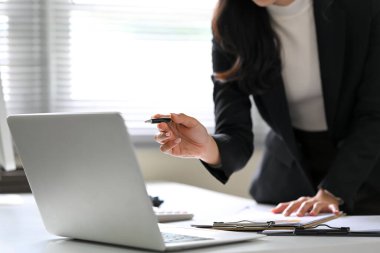 Finansal raporlar incelenirken dizüstü bilgisayarı işaret eden iş kadınının kapatılması.