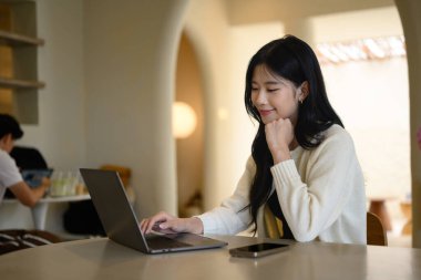 Rahat bir kafede dizüstü bilgisayar üzerinde çalışan serbest çalışan biri..