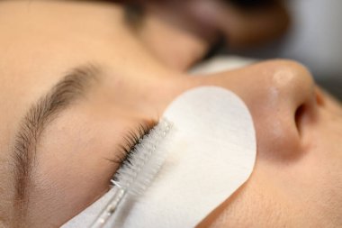 Kirpik teknisyeninin yeni sürttüğü kirpik eklentilerinin makro görüntüsü..