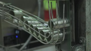 Boş alüminyum kutular otomatik balık konservesi fabrikasındaki metal kılavuz parmaklıklardan geçer..