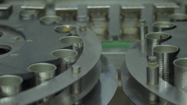 Deniz ürünleri konserve fabrikasında boş teneke kutuları taşıyan otomatik taşıma sisteminin görüntüsünü kapat.