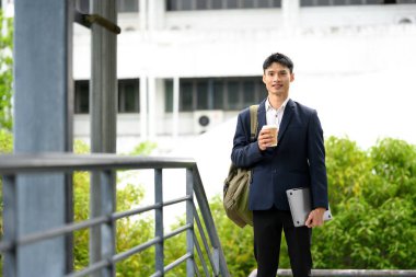 Kahve ve dizüstü bilgisayarla dışarıda duran işadamı verimli bir güne hazır..