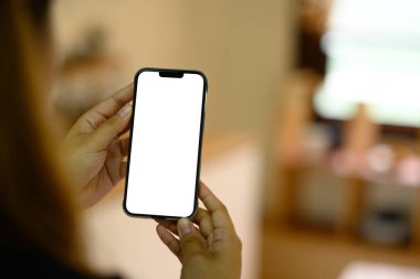 Mutfak arka planında cep telefonu kullanan eller.