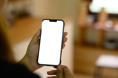 Uygulama veya web sitesi modeli için mutfakta boş ekranlı akıllı telefon tutan kişi.