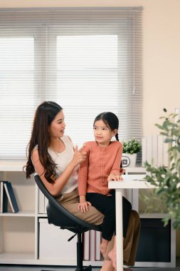 Anne, küçük kızına evde bilgisayar başında Çince öğretiyor..
