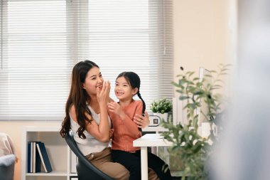 Anne ve çocuk aydınlık bir oturma odasında Çince telaffuz pratiği yapıyorlar..