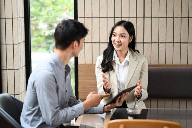 Erkek bir iş arkadaşıyla yaptığı toplantıda gülümseyen iş kadını fikirleri anlatıyor..