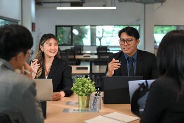 Bir grup profesyonel şirket toplantısında fikirleri tartışıyor..