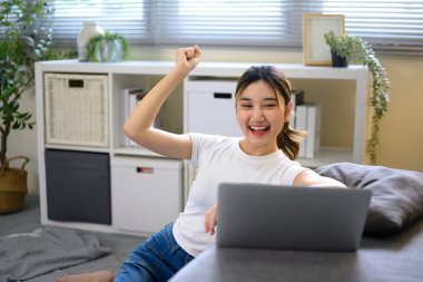 Çevrimiçi iş kilometre taşını geçtikten sonra tezahürat yapan mutlu kadın serbest yazar.