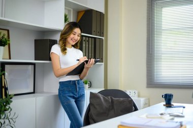 Önemli belgeleri inceleyen ve parlak çalışma alanında notlar yazan genç girişimci.