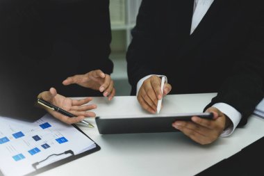 İş adamlarının dijital tablet ve dokümanlarla strateji tartışmalarını kapatın.