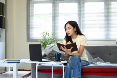 Odaklanmış Umman, çevrimiçi bir derse katılırken ya da evdeki dizüstü bilgisayarında toplanırken not alıyordu...