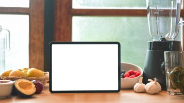 Taze meyve, sebze ve blender ile çevrili ahşap masa üzerinde boş ekran tablet modeli.