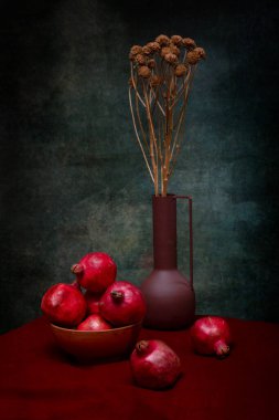 Olgun narlarla ve kurumuş çiçeklerle dolu vazoyla dolu bir hayat