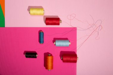 Renkli bir arkaplanda çok renkli ipliklerin bobinleri