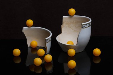 Still life with a broken pot and orange balls