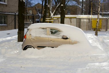 Winter landscape with car covered with snow