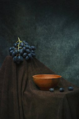 Still life with a plate and a bunch of ripe grapes