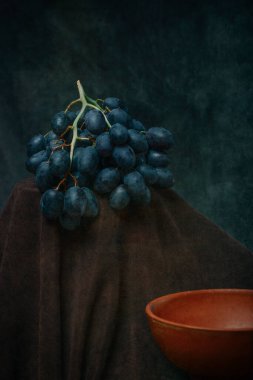 Still life with a plate and a bunch of ripe grapes