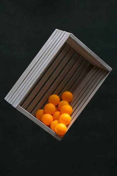 暗い背景に木製の箱のオレンジボール — ストック写真