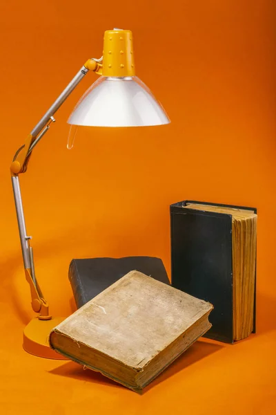 オレンジ色の背景にレーニンとスターリンのテーブルランプと本 — ストック写真