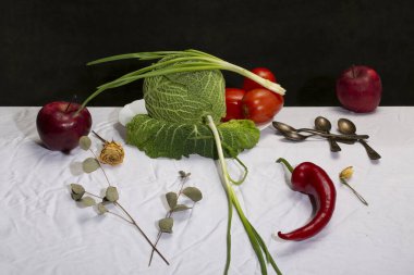 Savoy lahanası, sebzeler ve meyvelerle dolu beyaz bir masa örtüsü