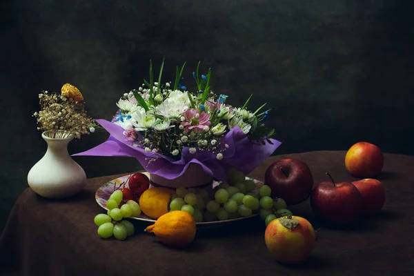 Still life with a bouquet of flowers and fruits