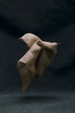 Karanlık bir arka planda havada bir çuval bezi.