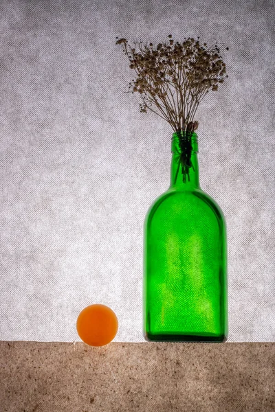 Натюрморт Зеленой Бутылкой Цветами Оранжевым Шариком — стоковое фото
