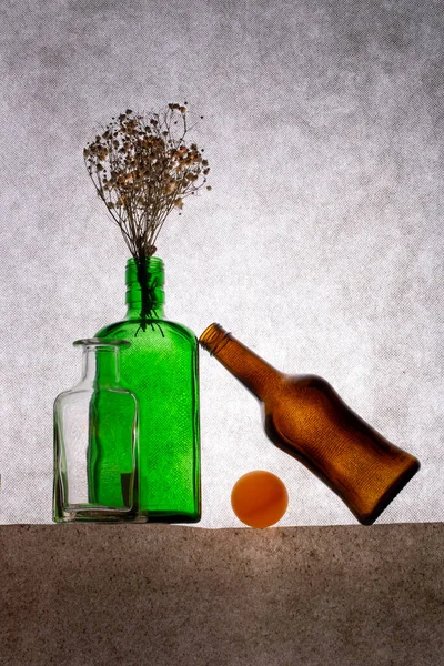 Stillleben Mit Farbigen Flaschen Und Getrockneten Pflanzenzweigen — Stockfoto