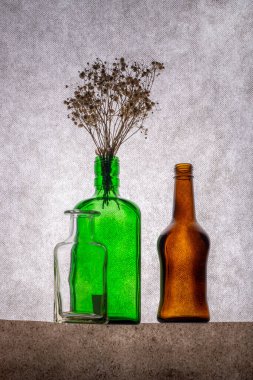 Renkli şişeler ve kurumuş bitki dallarıyla dolu sakin bir hayat.