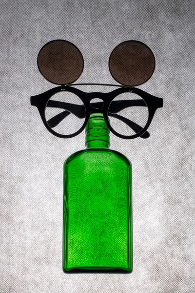 Färgade Glasflaska Med Solglasögon Grå Bakgrund — Stockfoto