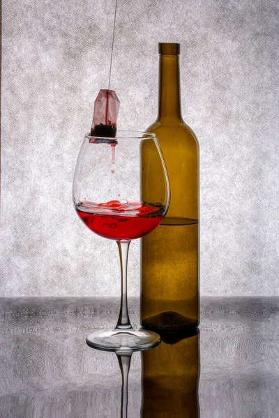 Een Fles Een Glas Met Rode Vloeistof Een Theezakje — Stockfoto