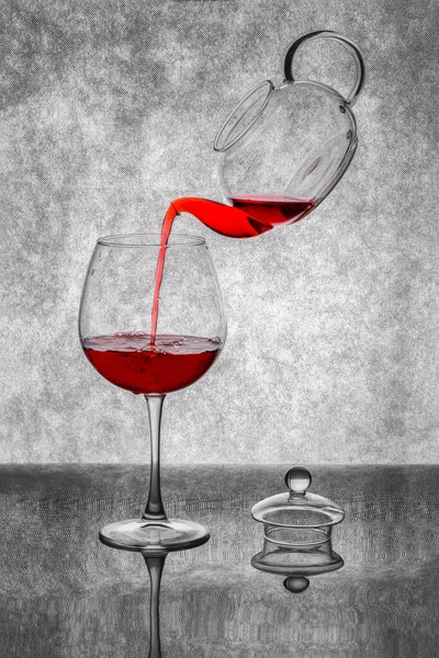 Versare Liquido Rosso Una Teiera Bicchiere Uno Sfondo Grigio — Foto Stock