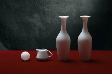 Kırmızı masadaki beyaz vazolarla hayat