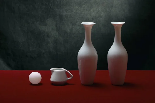 stock image Still life with white vases on a red table